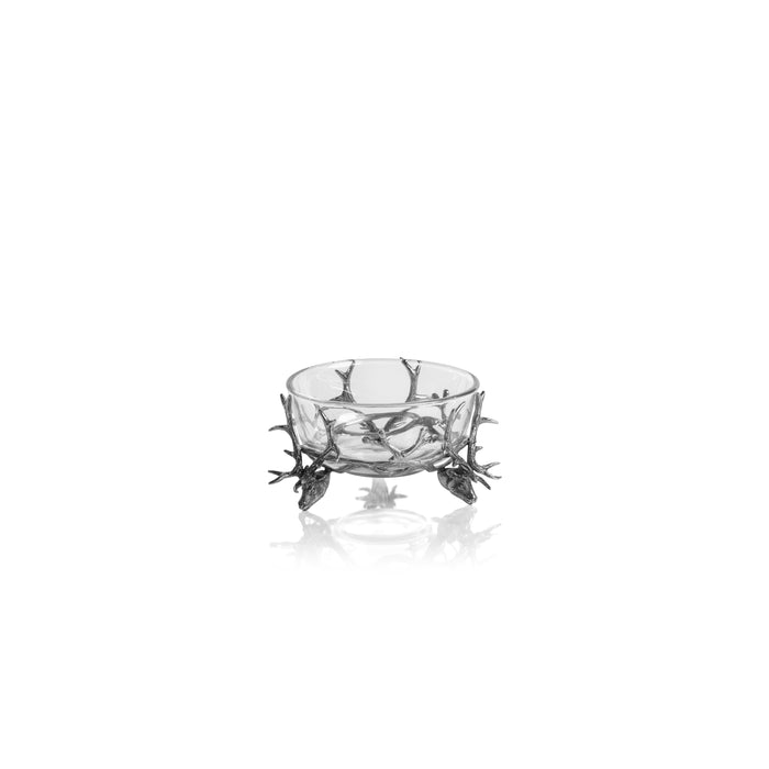 A clear glass bowl with pewter stag head feet and antler tops on a white background.