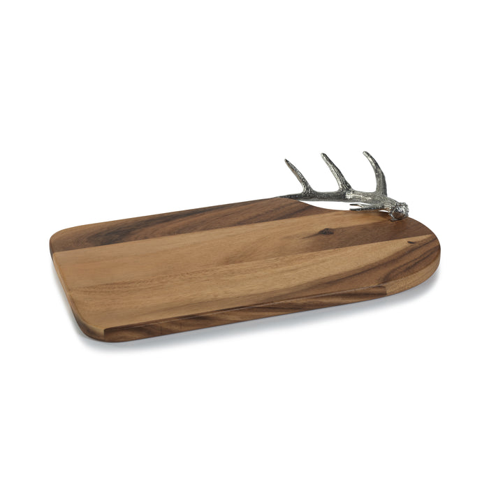 A rectangular wooden cheese and charcuterie board with a pewter antler handle on the top.