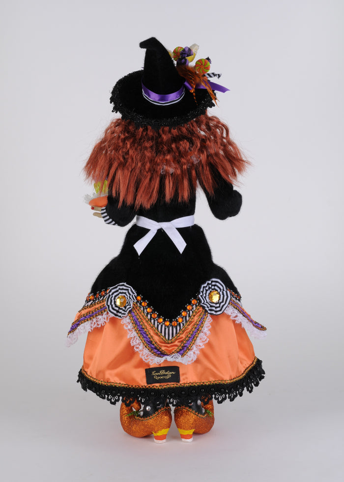 Halloween-themed doll with witch outfit on a white background