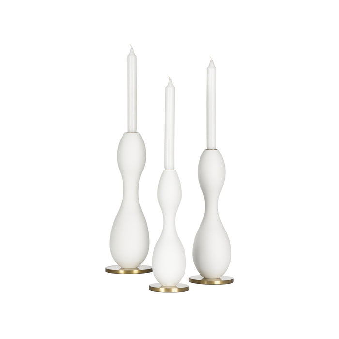 Three white candle holders with candles on a white background