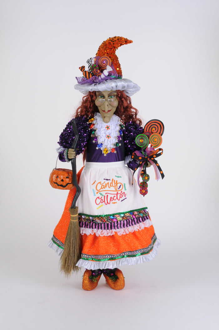 Decorative Halloween doll with colorful outfit and broom on a white background