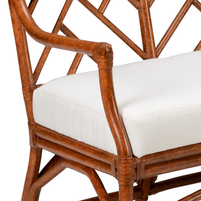 Brown wicker chair with a white cushion on a white background