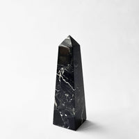 Black marble obelisk object on a white background