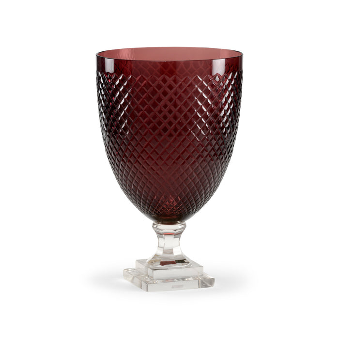 Red glass with textured design on a white background