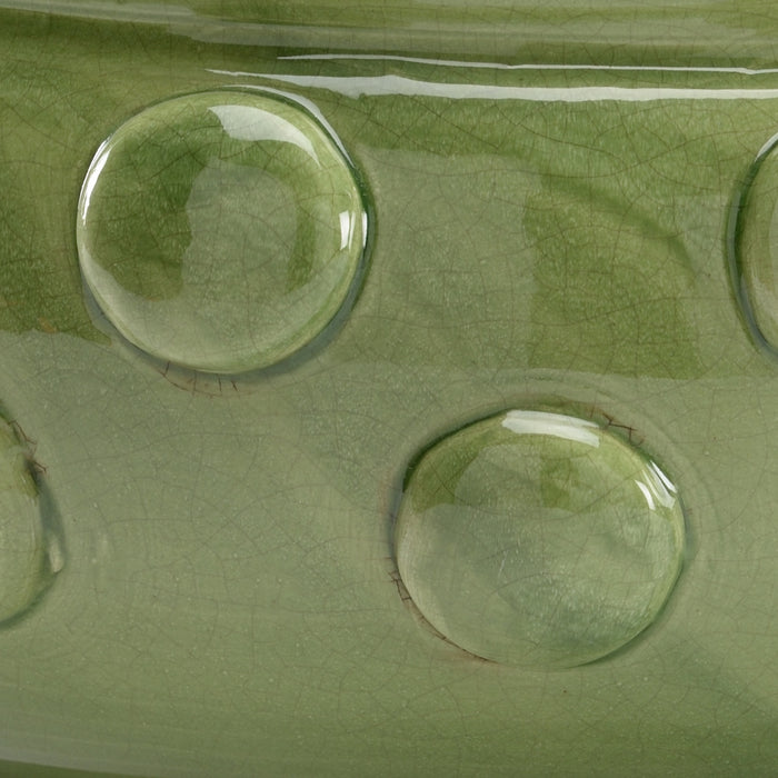 Close-up of a green ceramic surface with circular depressions