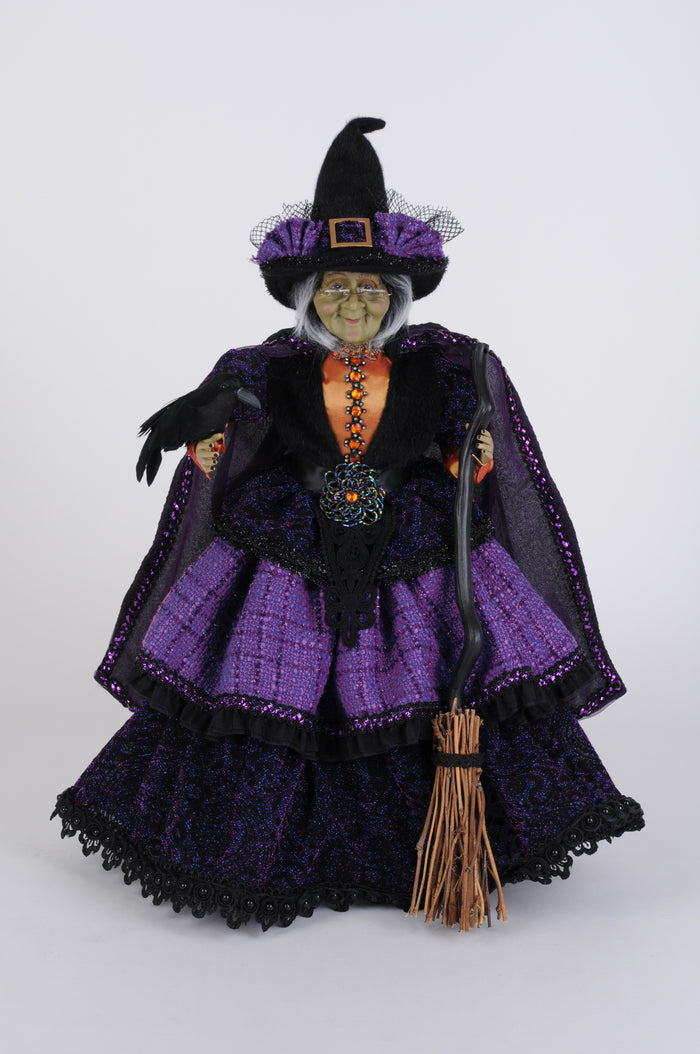 Halloween witch figurine with purple and black outfit on a white background