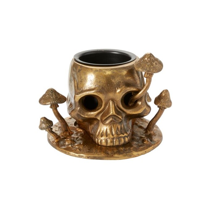 Gold skull-shaped candle holder with mushrooms on a white background