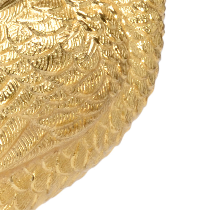 Close-up of a gold decorative object with intricate patterns on a white background