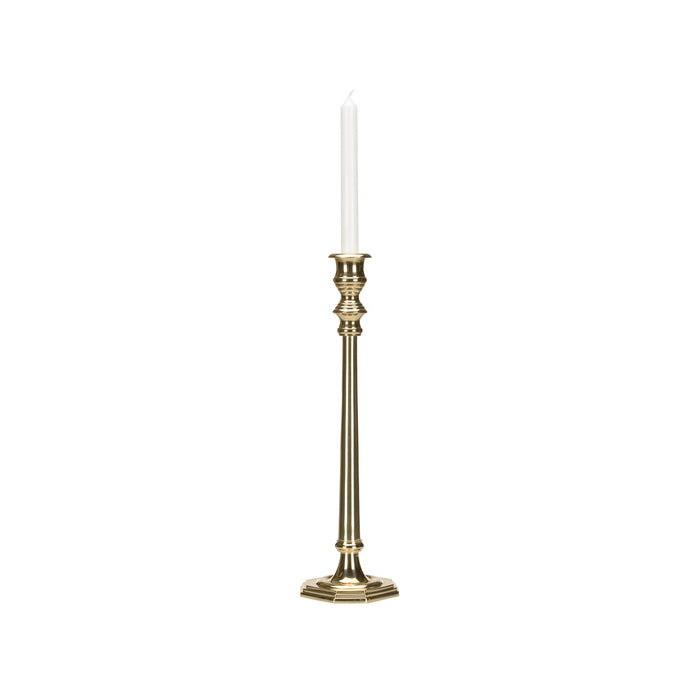 Gold candlestick holder with a white candle on a white background