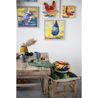 Dining room with a wooden table and chairs, featuring colorful chicken paintings on the wall.