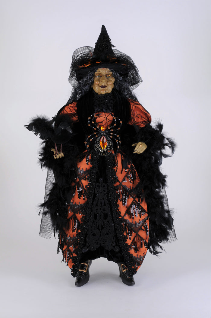 Halloween witch figurine with black and orange dress on a white background