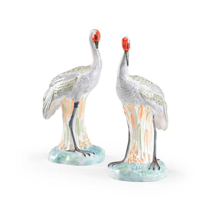 Two glass cranes with red eyes on a white background