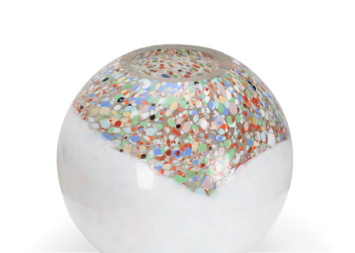 Glass paperweight with multicolored speckles on a white background