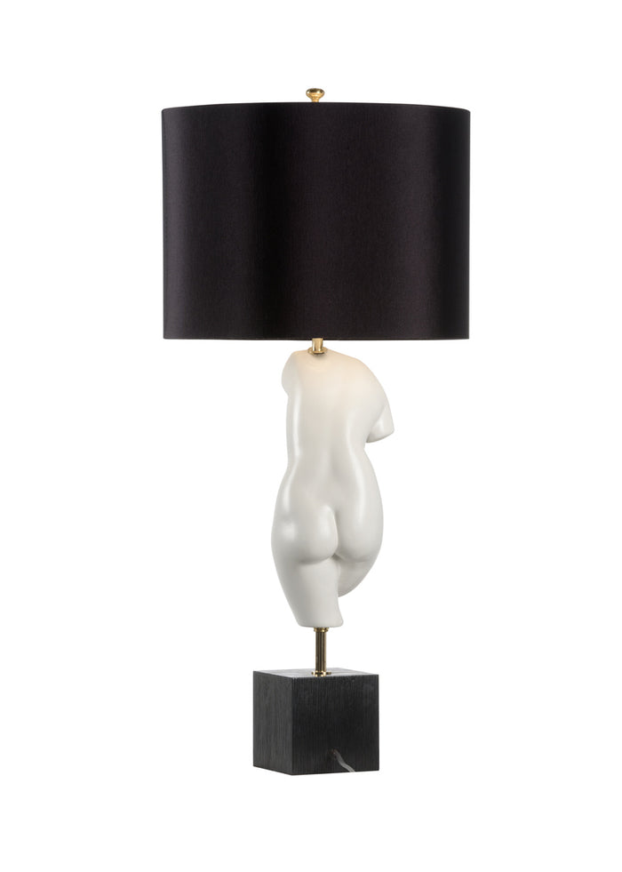 Table lamp with a black shade and abstract white base on a white background