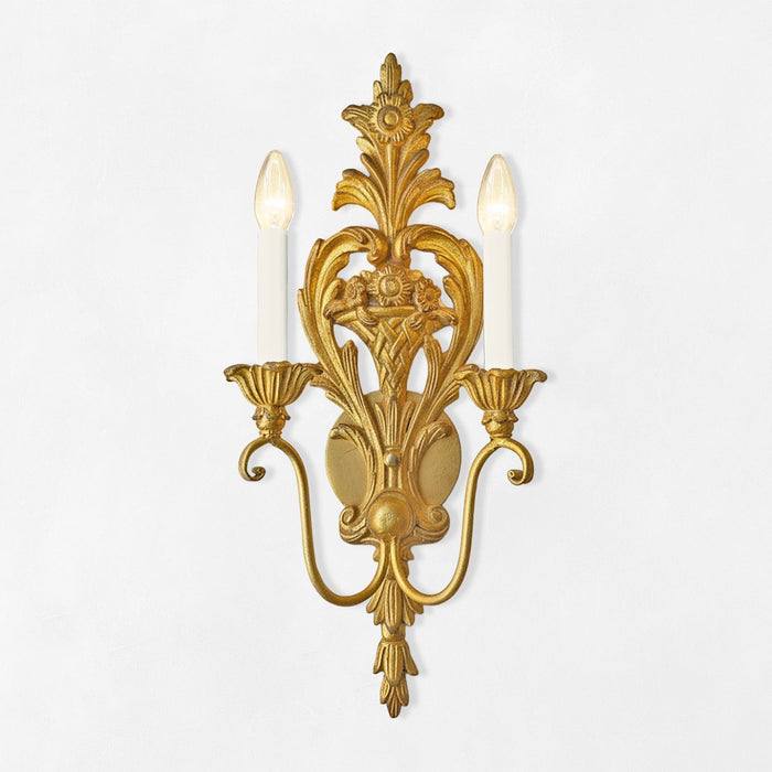 Decorative gold wall sconce with two candle lights on a white background