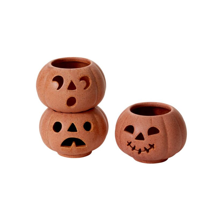 Three terracotta pots with jack-o'-lantern faces on a white background