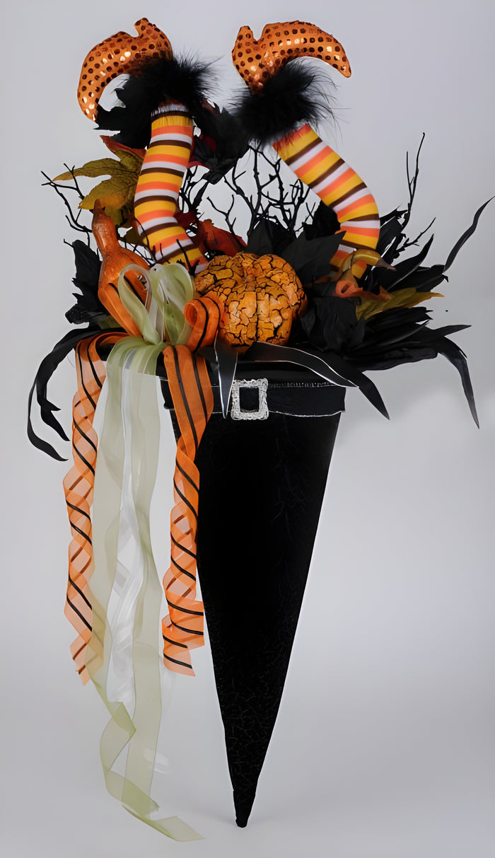 Halloween-themed decoration with a black hat, orange pumpkins, and striped legs on a white background