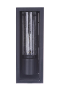 Cylindrical clear glass outdoor wall light with a textured pattern, mounted in a rectangular black frame against a dark