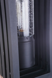 Carmel outdoor wall lantern in textured black with a clear glass tube and visible inner bulb, set within a dark metal frame.