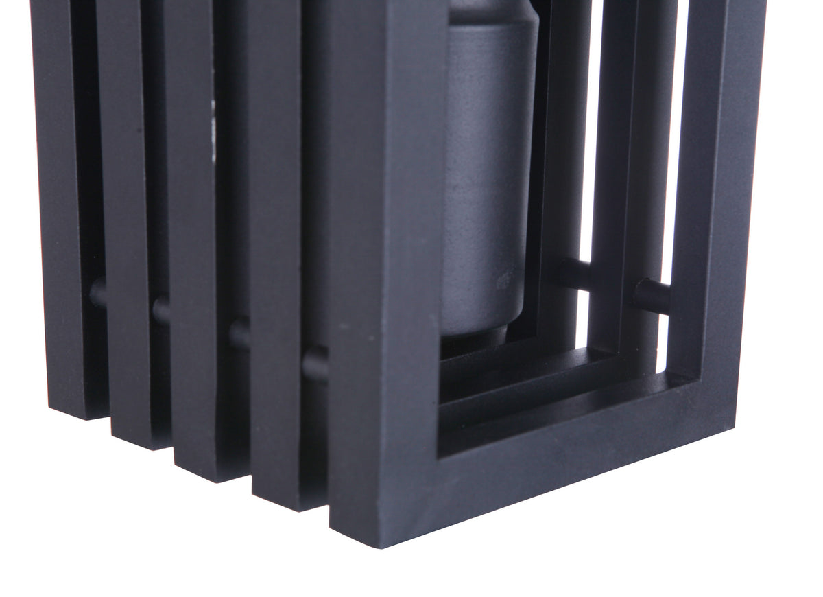 Textured black outdoor wall lantern with stacked rectangular frame slats, mounted around a cylindrical light element.