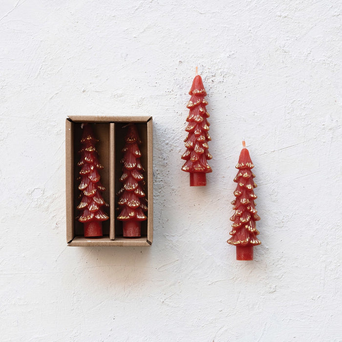 Set of two unscented red tree-shaped taper candles with gold tips in a brown box, plus two separate candles on white