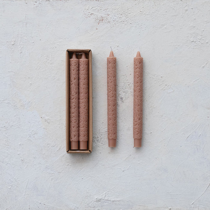 Set of two unscented maple leaf pattern taper candles in pink-taupe, with one pair in a cardboard box and two standalone