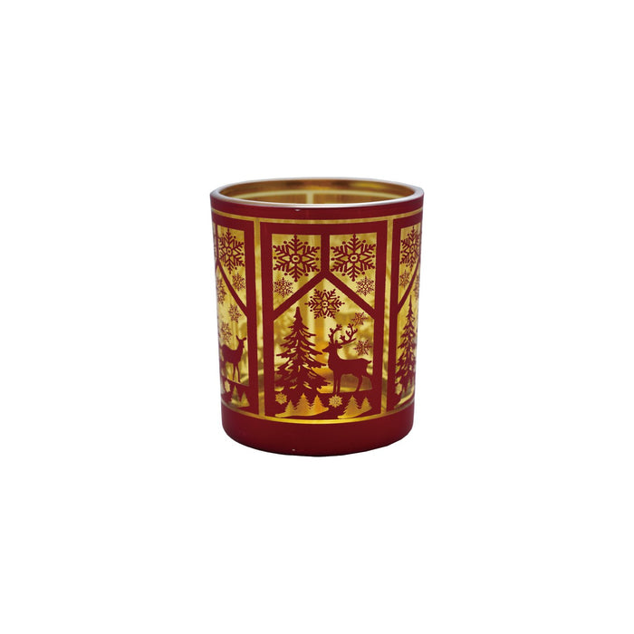 A red glass tealight holder with laser etched window scene including trees and snowflakes.